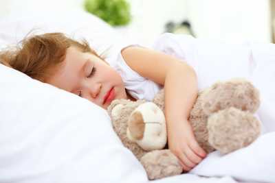 Girl sleeps with teddy bear